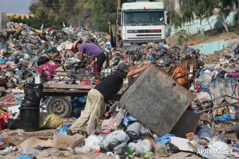 Palestinian workers of the Gaza municipality collect rubbish in Gaza city on July 27, 2014. Three Palestinians were killed in shelling as the Israeli military resumed its assault on Gaza after Hamas shunned an extended l...