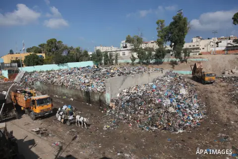 Palestinian workers of the Gaza municipality collect rubbish in Gaza city on July 27, 2014. Three Palestinians were killed in shelling as the Israeli military resumed its assault on Gaza after Hamas shunned an extended l...