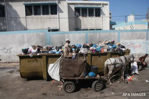 Palestinian workers of the Gaza municipality collect rubbish in Gaza city on July 27, 2014. Three Palestinians were killed in shelling as the Israeli military resumed its assault on Gaza after Hamas shunned an extended l...