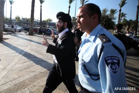 Israeli policemen detain a member of Neturei Karta Jews protester during a protest against the Israeli offensive on the Gaza Strip, in front of Damascus gate in Jerusalem's Old City July 27, 2014. Palestinian medics said...
