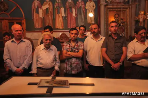Palestinian relatives and friends of Jalila Ayad, a Christian woman whose body was found under the rubble of her home after an Israeli airstike, pray over her coffin during a religious service as part of her funeral on J...