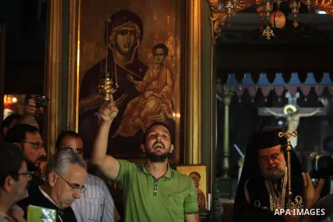 Palestinian relatives and friends of Jalila Ayad, a Christian woman whose body was found under the rubble of her home after an Israeli airstike, pray over her coffin during a religious service as part of her funeral on J...