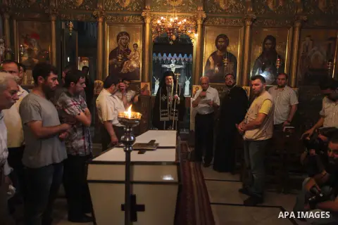 Palestinian relatives and friends of Jalila Ayad, a Christian woman whose body was found under the rubble of her home after an Israeli airstike, pray over her coffin during a religious service as part of her funeral on J...