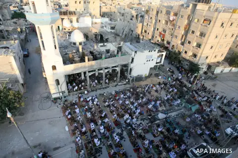 Palestinian muslims attends the Eid al-Fitr prayer at al-Farouk mosque, which witnesses said was hit by an Israeli air strike, in Rafah in the southern Gaza Strip July 28, 2014. The U.N. Security Council agreed on a stat...