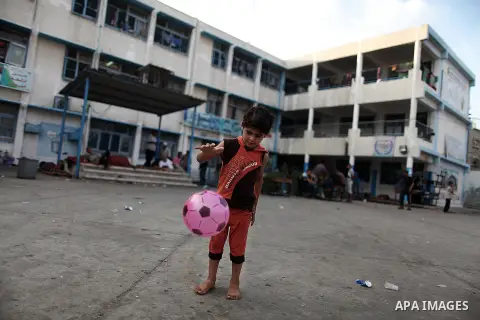A displaced Palestinian boy plays as he celebrating the Eid al-Fitr festival at a United Nations school, in Gaza City on July 28, 2014. The U.N. Security Council agreed on a statement on Sunday urging Israel, Palestinian...