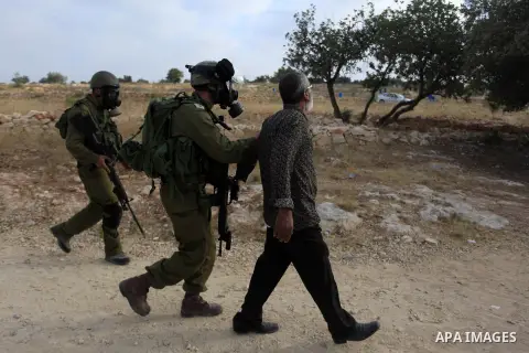 Israeli security forces detain a Palestinian protesters during clashes in following the Eid al-Fitr prayer in a protest against the Israeli military operation on Gaza Strip, in the West Bank villages of Bilin, near Ramal...