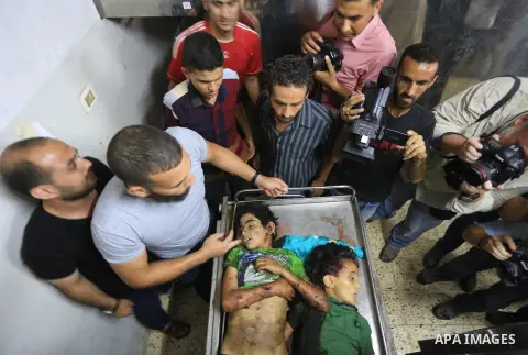 Palestinian men surround the bodies of two children at the morgue of Gaza City's al-Shifa hospital after an explosion killed at least seven children in a public playground in the beachfront Shati refugee camp on July 28,...
