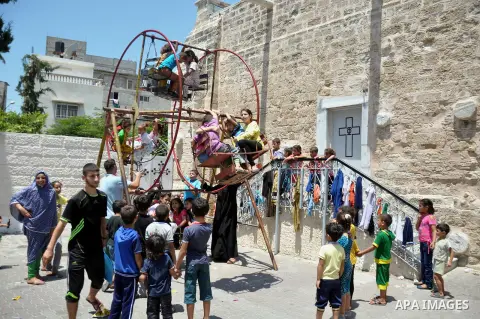 Displaced Palestinian children play as they are celebrating the Eid al-Fitr festival at the Saint Porphyrios church, in Gaza city on July 28, 2014. Security Council agreed on a statement urging Israel, Palestinians and I...