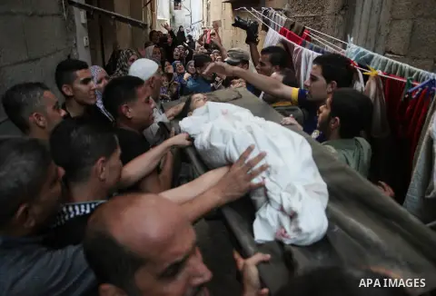 Palestinians chant slogans while carrying the body, who was killed along with 9 other people, all but one of them children, in an explosion at a park at the Shati refugee camp, in the northern Gaza Strip, Monday, July 28...