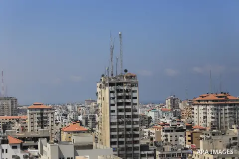 The top floors of Al Shorouk tower, housing media offices, can be seen damaged after they were hit by an overnight Israeli strike, in Gaza City, northern Gaza Strip, Tuesday, July 29, 2014. Early Tuesday, Israel warplane...