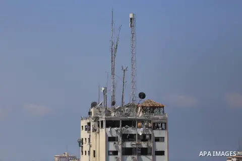 The top floors of Al Shorouk tower, housing media offices, can be seen damaged after they were hit by an overnight Israeli strike, in Gaza City, northern Gaza Strip, Tuesday, July 29, 2014. Early Tuesday, Israel warplane...