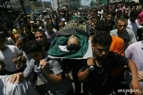 Palestinian relatives carry the body of a man, killed in an Israeli air strike on their home, during his funeral in Khan Younis in the southern Gaza Strip on July 29, 2014. Israel's bombardment of Gaza left dozens more P...