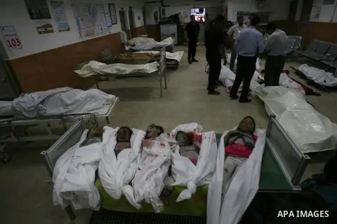 Palestinian man looks at the bodies of Palestinian children, whom medics said were killed in an Israeli air strike that destroyed a house they were staying at, in Khan Younis in the southern Gaza Strip July 29, 2014. Isr...