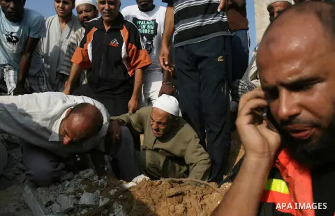 Palestinian rescue workers carry the body of a member of Duheir family, after removing it from under the rubble of a building destroyed by an Israeli air strike in Rafah on July 29, 2014, in the southern of Gaza strip. B...
