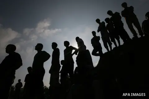 Palestinians look at rescue workers as they search for victims under the rubble of a house, which witnesses said was destroyed in an Israeli air strike, in Rafah in the southern Gaza Strip July 29, 2014. Israel's militar...
