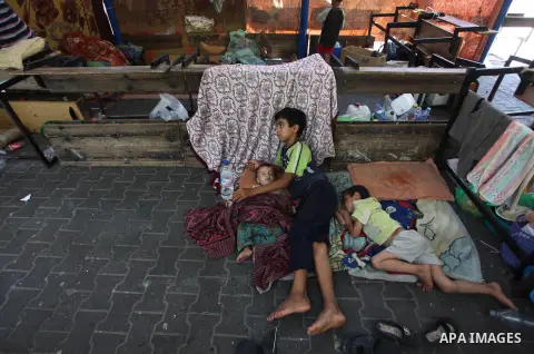 Displaced Palestinian children rest at the Abu Hussien UN school in the Jabalia refugee camp in the northern Gaza Strip after the area was hit earlier in the morning by Israeli shelling on July 30, 2014. Israeli bombardm...