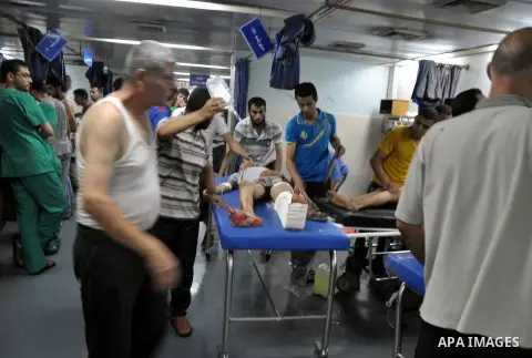 Palestinians wheel a wounded man, injured from an Israeli Strike in Shijaiyah neighborhood, to an emergency room at Shifa Hospital, in Gaza City, Wednesday, July 30, 2014. Photo by Mohammed Talatene