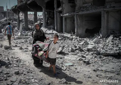 Palestinians carry their belongings after salvaging them from their destroyed house in the heavily bombed town of Beit Hanoun, Gaza Strip, close to the Israeli border, Friday, Aug. 1, 2014. A three-day Gaza cease-fire th...