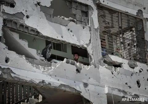 Palestinians carry their belongings after salvaging them from their destroyed house in the heavily bombed town of Beit Hanoun, Gaza Strip, close to the Israeli border, Friday, Aug. 1, 2014. A three-day Gaza cease-fire th...