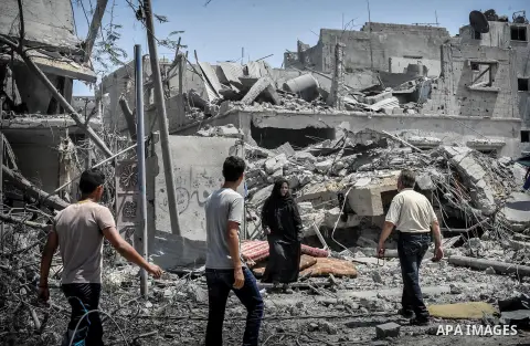 Palestinians carry their belongings after salvaging them from their destroyed house in the heavily bombed town of Beit Hanoun, Gaza Strip, close to the Israeli border, Friday, Aug. 1, 2014. A three-day Gaza cease-fire th...