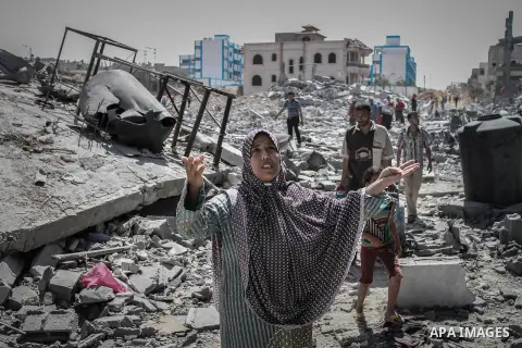 Palestinians carry their belongings after salvaging them from their destroyed house in the heavily bombed town of Beit Hanoun, Gaza Strip, close to the Israeli border, Friday, Aug. 1, 2014. A three-day Gaza cease-fire th...