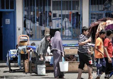 Displaced Palestinians gather at an United Nations (UN) school in Beit Lahia in the northern Gaza Strip, where they and his family found refuge after fleeing their home in an area under heavy Israeli bombardment in the b...