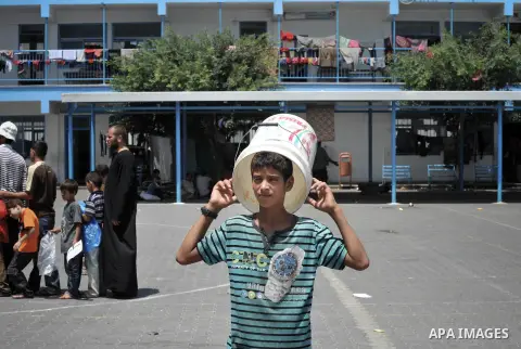 Displaced Palestinians gather at an United Nations (UN) school in Beit Lahia in the northern Gaza Strip, where they and his family found refuge after fleeing their home in an area under heavy Israeli bombardment in the b...