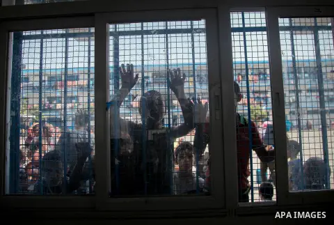 Displaced Palestinians gather at an United Nations (UN) school in Beit Lahia in the northern Gaza Strip, where they and his family found refuge after fleeing their home in an area under heavy Israeli bombardment in the b...
