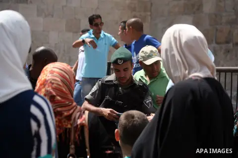 Israeli policemen check documents and belongings of Palestinian worshippers as they preventing them from entering the Al-Aqsa mosque compound in the Old City of Jerusalem on August 3, 2014. Photo by Saeed Qaq