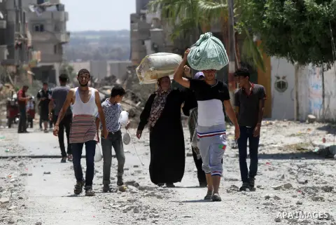 Palestinians carry belongings as they walk over the rubble of buildings destroyed by what police said were Israeli air strikes and shelling in Khuzaa, east of Khan Younis, in the southern Gaza Strip August 3, 2014. An Is...