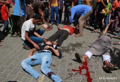 Men inspect the lifeless and wounded Palestinians outside a UN run school in Rafah, in the southern Gaza Strip, Sunday, Aug. 3, 2014. At least 10 people were killed in a fresh strike on a UN school in southern Gaza which...