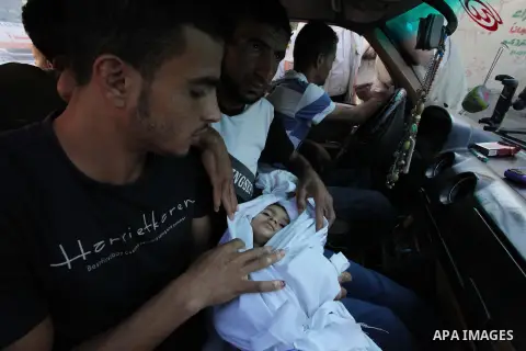 relative sits in a car as he carries the body of two-and-a-half-year-old Palestinian girl Raghad Massoud, whom medics said was killed in an Israeli air strike, before her burial in Rafah in the southern Gaza Strip August...
