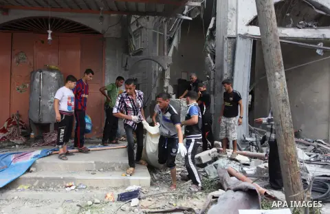Palestinians carry the dead body of a woman after removing it from under the rubble of a house which witnesses said was destroyed in an Israeli air strike, in Rafah in the southern Gaza Strip August 4, 2014. Palestinians...