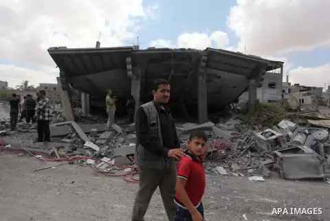 Palestinians gather as rescue workers search for victims under the rubble of a house which witnesses said was destroyed in an Israeli air strike, in Rafah in the southern Gaza Strip August 4, 2014. Palestinians accused I...