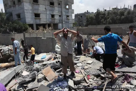 Palestinians gather as rescue workers search for victims under the rubble of a house which witnesses said was destroyed in an Israeli air strike, in Rafah in the southern Gaza Strip August 4, 2014. Palestinians accused I...