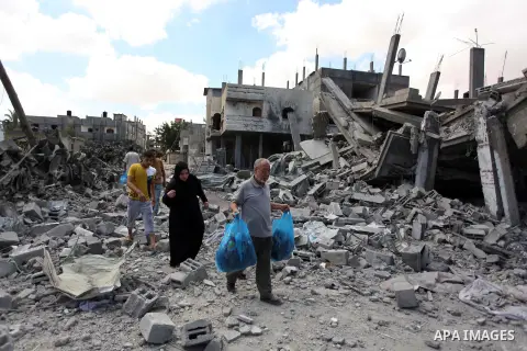 Palestinians walk upon the debris of a house which witnesses said was destroyed in an Israeli air strike, in Rafah in the southern Gaza Strip August 4, 2014. Palestinians accused Israel of breaking its own ce asefire on...