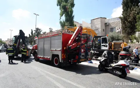 Israeli rescue workers stand near a body at the scene of an attack in Jerusalem, Monday, Aug. 4, 2014. An Israeli-declared cease-fire and troop withdrawals slowed violence in the Gaza war Monday, though an attack on Isra...