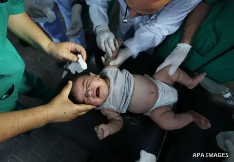 Palestinian medics treat an infant, whom medics said was wounded in an Israeli air strike, at a hospital in Rafah in the southern Gaza Strip August 4, 2014. A brief Israeli truce to allow aid to reach Palestinians ended...