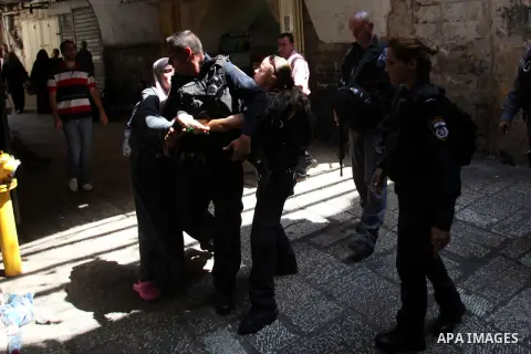 A Palestinian woman clashes with Israeli police officers as they block a road that leads to the al-Aqsa mosque compound, in Jerusalem's Old City on August 05, 2014. Israeli policemen closed the mosque's main gates and al...