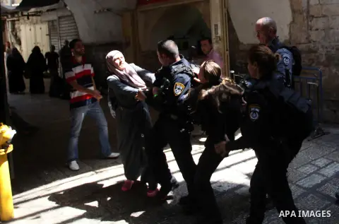 A Palestinian woman clashes with Israeli police officers as they block a road that leads to the al-Aqsa mosque compound, in Jerusalem's Old City on August 05, 2014. Israeli policemen closed the mosque's main gates and al...