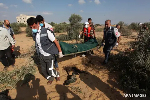 Medics carry the dead body of a Palestinian man after removing it from under the rubble of a house which witnesses said was destroyed during the Israeli offensive, in the east of Rafah in the southern Gaza Strip August 5...