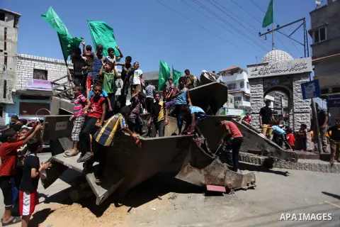 Palestinian children play on the remains of a destroyed Israeli military vehicle, in the east of Khan Younis in the southern Gaza Strip August 5, 2014. Israel pulled its ground forces out of the Gaza Strip on Tuesday and...