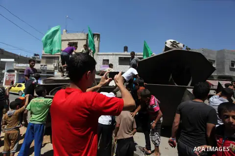 Palestinian children play on the remains of a destroyed Israeli military vehicle, in the east of Khan Younis in the southern Gaza Strip August 5, 2014. Israel pulled its ground forces out of the Gaza Strip on Tuesday and...