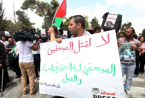 Palestinian journalists carry mock coffins during a demonstration for their colleagues killed while covering the Israeli military offensive in Gaza, in the West Bank city of Ramallah on August 5, 2014. Gaza fell silent t...