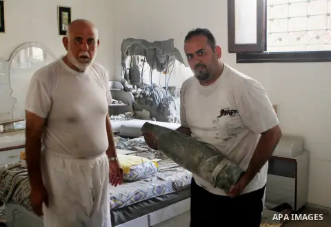A Palestinian man holds the remains of an Israeli shell at his damaged house at al-Shijaiyah neighborhood in the east of Gaza City August 5, 2014. Israel pulled its ground forces out of the Gaza Strip on Tuesday and bega...
