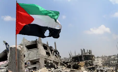 A Palestinian flag waves over the rubble of a house, which witnesses said was badly damaged during the Israeli offensive, at al-Shijaiyah neighborhood in the east of Gaza City August 5, 2014. Israel pulled its ground for...