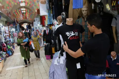 A Palestinian vendor display a mannequin wearing a T-Shirt written on them "We Are All Gaza" in support of the people of the Gaza Strip, at his shop in the West Bank city of Nablus, on August 5, 2014. Israel pulled its g...