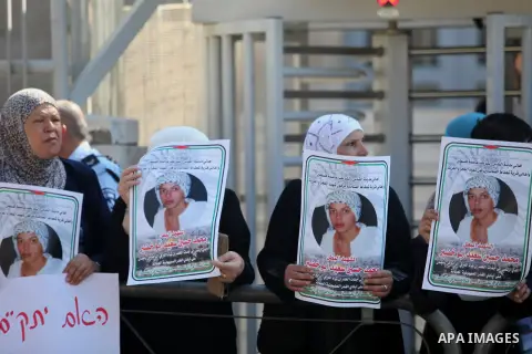 Palestinians hold signs and posters depicting Palestinian teen Mohammed Abu Khudair during a protest outside Jerusalem District Court August 6, 2014. Jerusalem District Court on Wednesday remanded Yosef Ben David, one of...