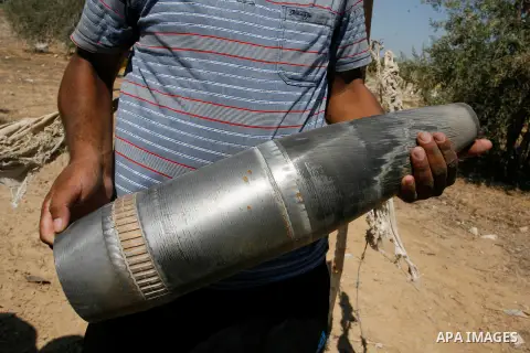 A Palestinian man holds an Israeli shell, which witnesses said was fired during the Israeli offensive, in the east of Rafah in the southern Gaza Strip August 6, 2014. Israel pulled its last soldiers out of the Gaza Strip...