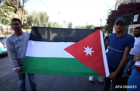 Palestinian protesters hold flag of Jordan during a protest against the Israeli offensive on Gaza Strip, outside the Red Cross headquarter in east Jerusalem's Sheikh Jarrah neighborhood on August 07, 2014, while diplomat...